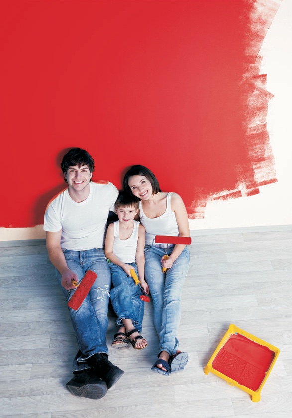 Familie streicht gemeinsam die Wand ihrer neuen Wohnung